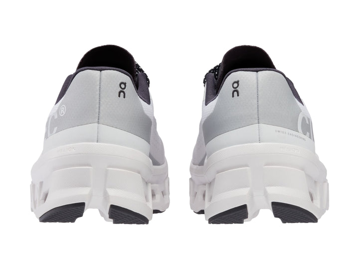 Tenis deportivos On Cloudmonster color blanco con detalles negros y suela amortiguada.