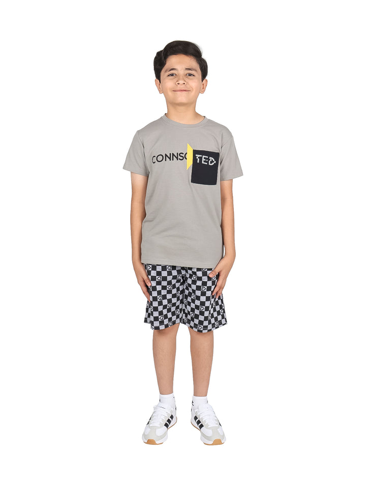 Niño vistiendo un conjunto de camiseta gris y short a cuadros blanco y negro.