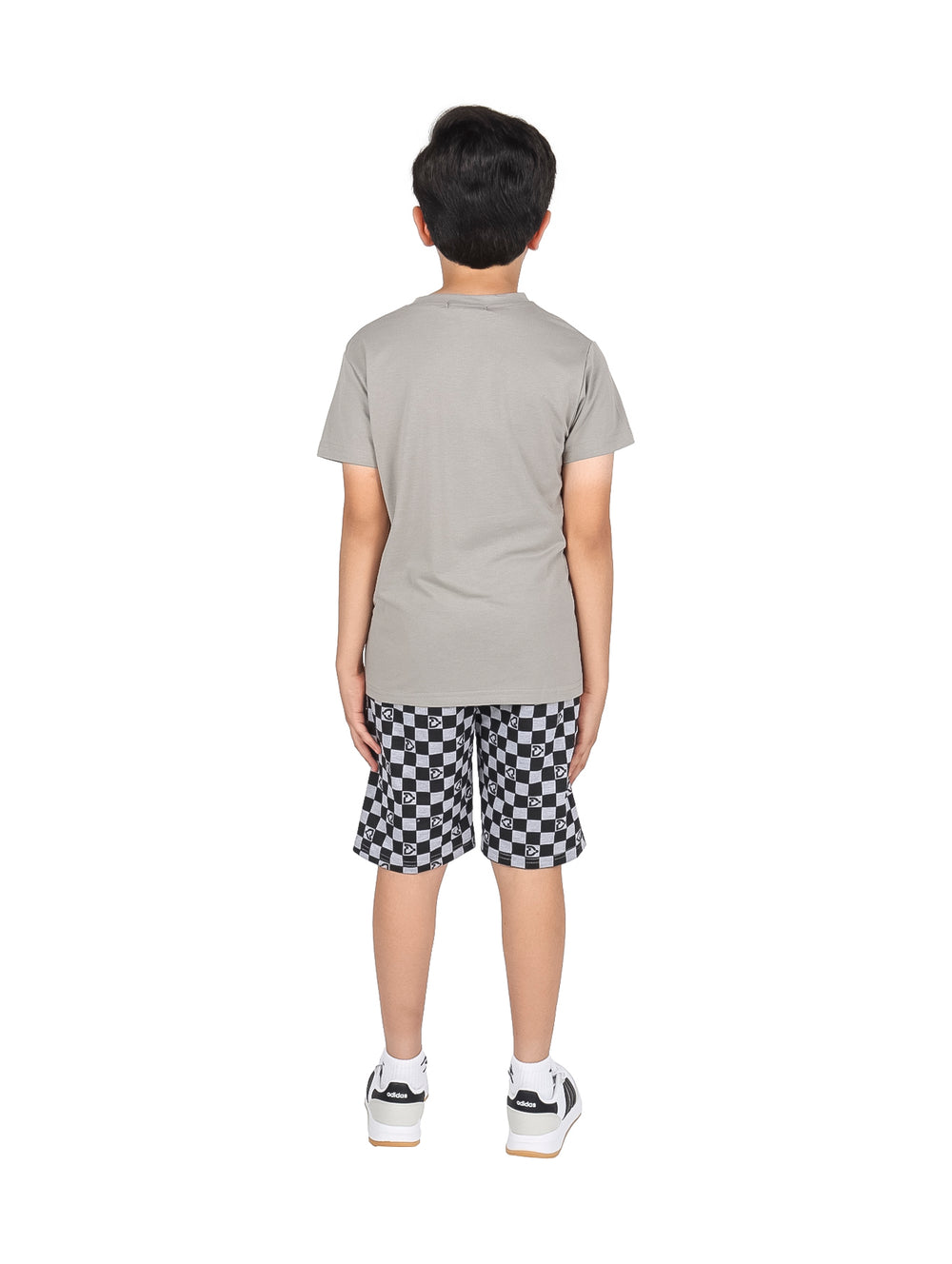 Niño vistiendo un conjunto de camiseta gris y short a cuadros blanco y negro.