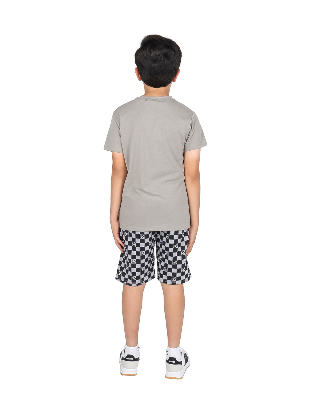 Niño vistiendo un conjunto de camiseta gris y short a cuadros blanco y negro.