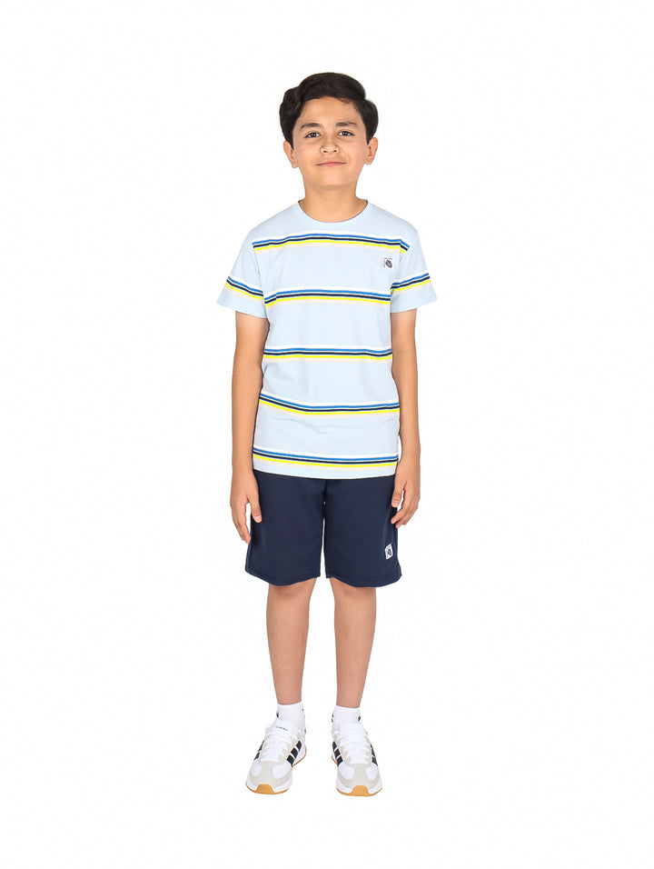 Niño vistiendo un conjunto de camiseta blanca a rayas azules y amarillas con short azul marino.