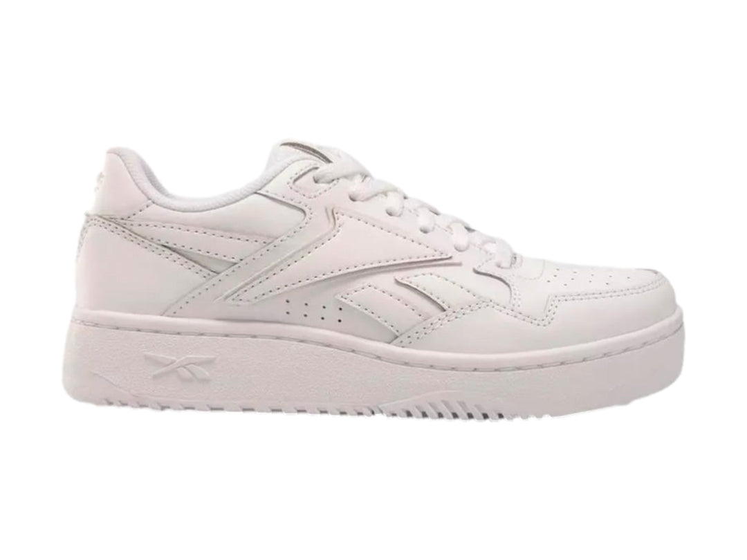 Tenis deportivos Reebok color blanco con suela ancha y cordones, vista lateral sobre fondo blanco.
