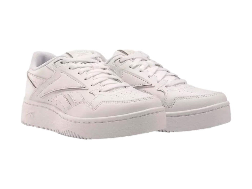Tenis deportivos Reebok color blanco con suela ancha y cordones, vista lateral sobre fondo blanco.