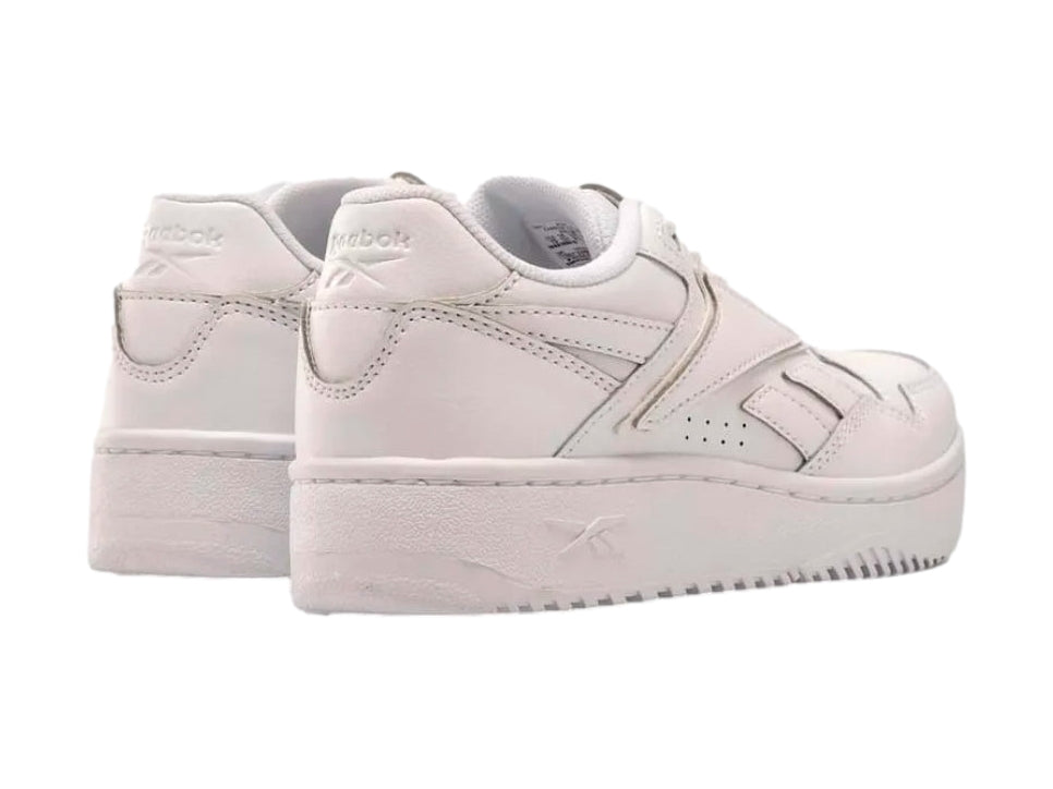 Tenis deportivos Reebok color blanco con suela ancha y cordones, vista lateral sobre fondo blanco.