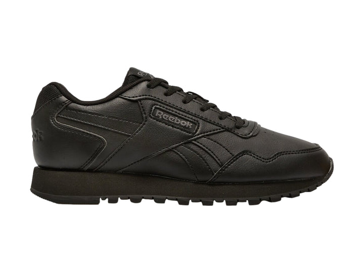 Tenis deportivos Reebok color negro para niños con suela dentada y cierre de cordones.