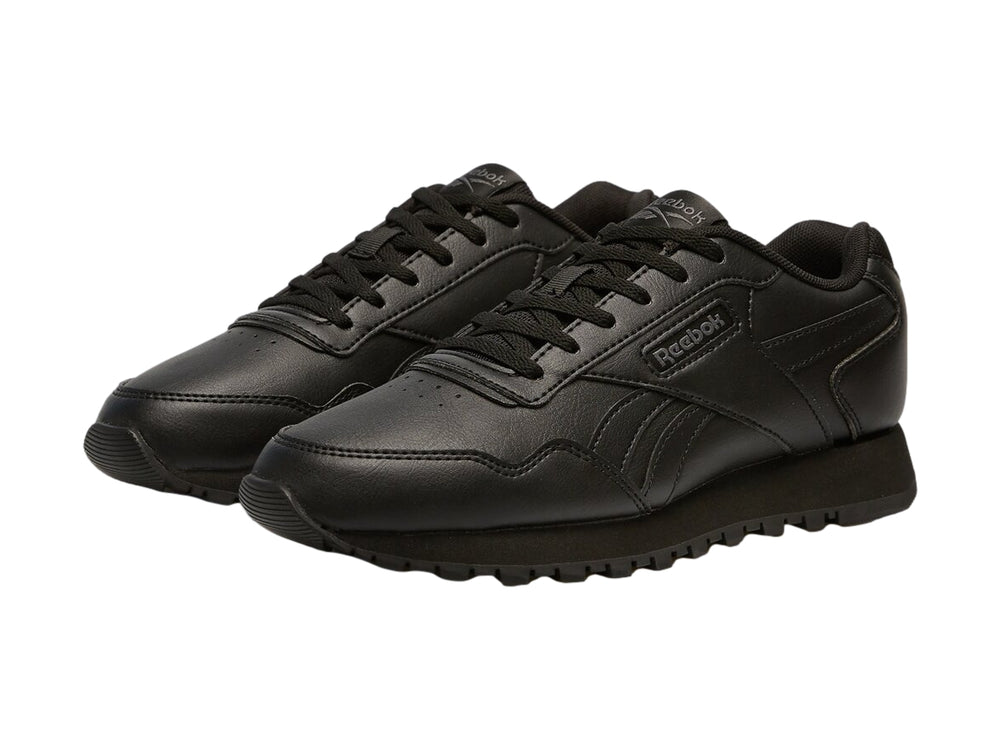 Tenis deportivos Reebok color negro para niños con suela dentada y cierre de cordones.