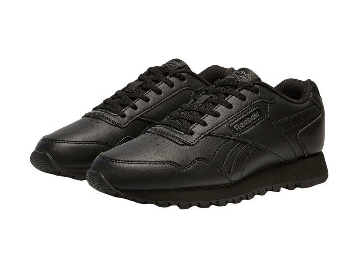 Tenis deportivos Reebok color negro para niños con suela dentada y cierre de cordones.