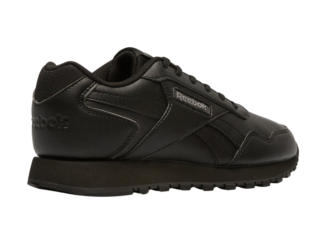 Tenis deportivos Reebok color negro para niños con suela dentada y cierre de cordones.