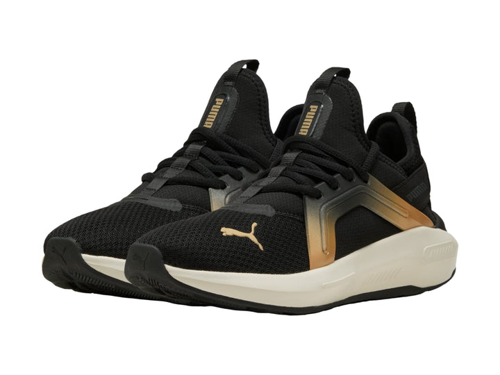 Tenis PUMA negros con acento dorado metálico y suela blanca, vista lateral.
