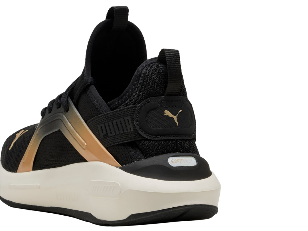 Tenis PUMA negros con acento dorado metálico y suela blanca, vista lateral.