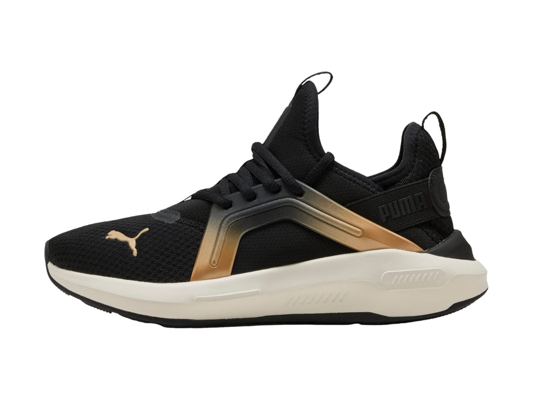 Tenis PUMA negros con acento dorado metálico y suela blanca, vista lateral.