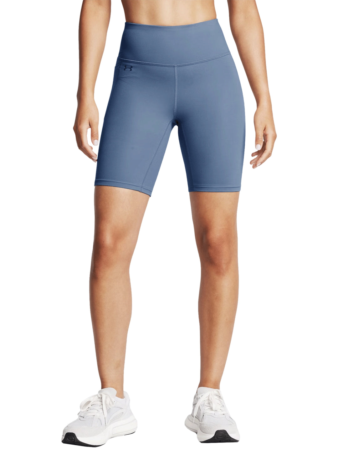Mujer vistiendo biker shorts deportivos de color gris de la marca Under Armour.