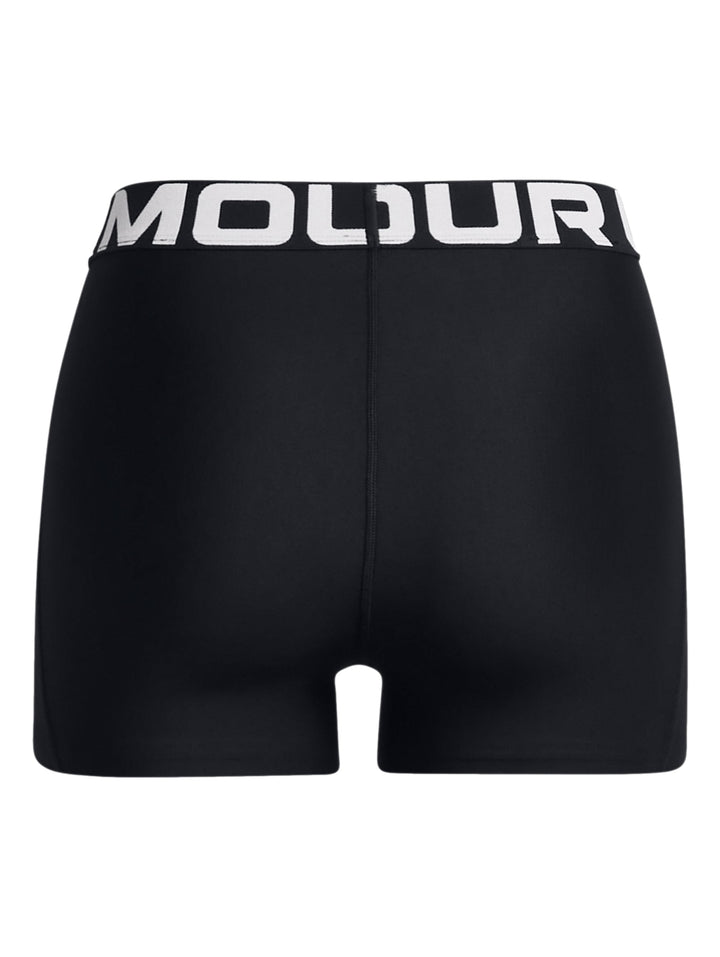Mujer vistiendo shorts deportivos de compresión Under Armour en color negro con cinturilla blanca.