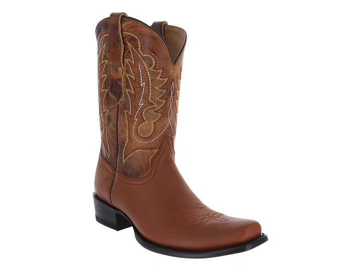 Bota vaquera de cuero color miel con bordados decorativos y suela negra.