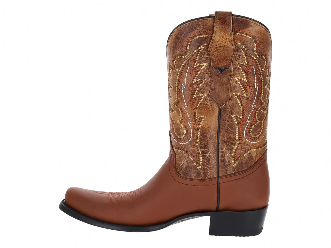 Bota vaquera de cuero color miel con bordados decorativos y suela negra.