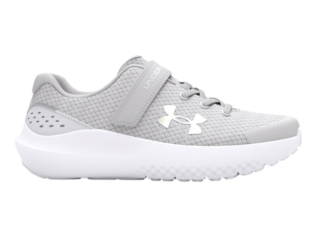 Tenis deportivos Under Armour color gris con suela blanca y correa de ajuste.