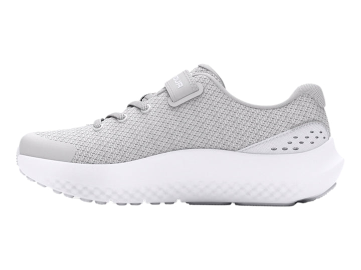 Tenis deportivos Under Armour color gris con suela blanca y correa de ajuste.