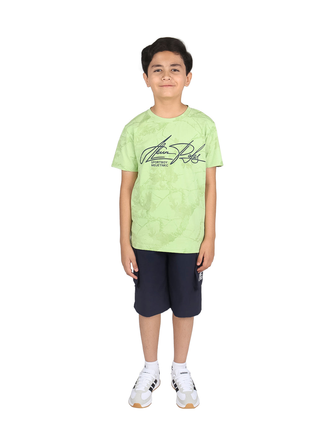 Niño modelando un conjunto de camiseta verde claro y shorts negros.