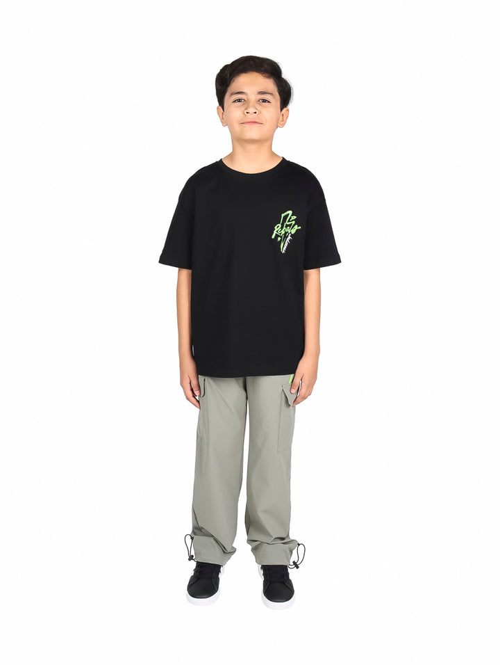 Niño vistiendo un conjunto de camiseta negra y pantalón cargo gris.