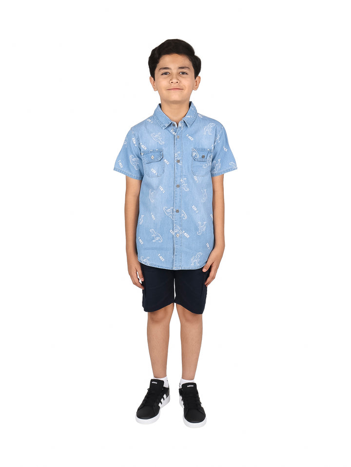 Niño vistiendo un conjunto de camisa azul claro estampada y short negro.