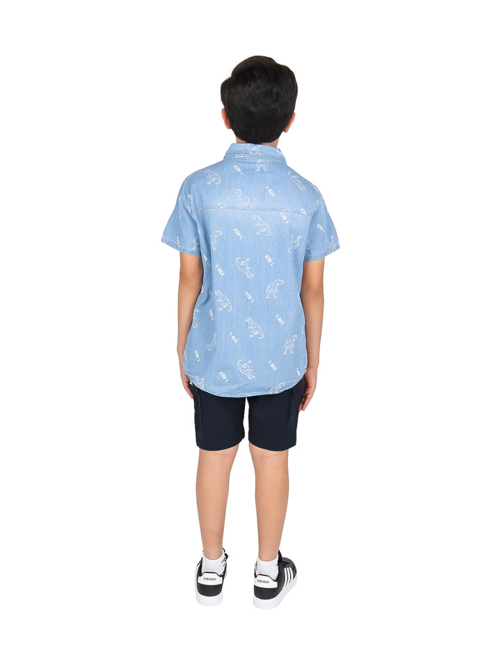 Niño vistiendo un conjunto de camisa azul claro estampada y short negro.