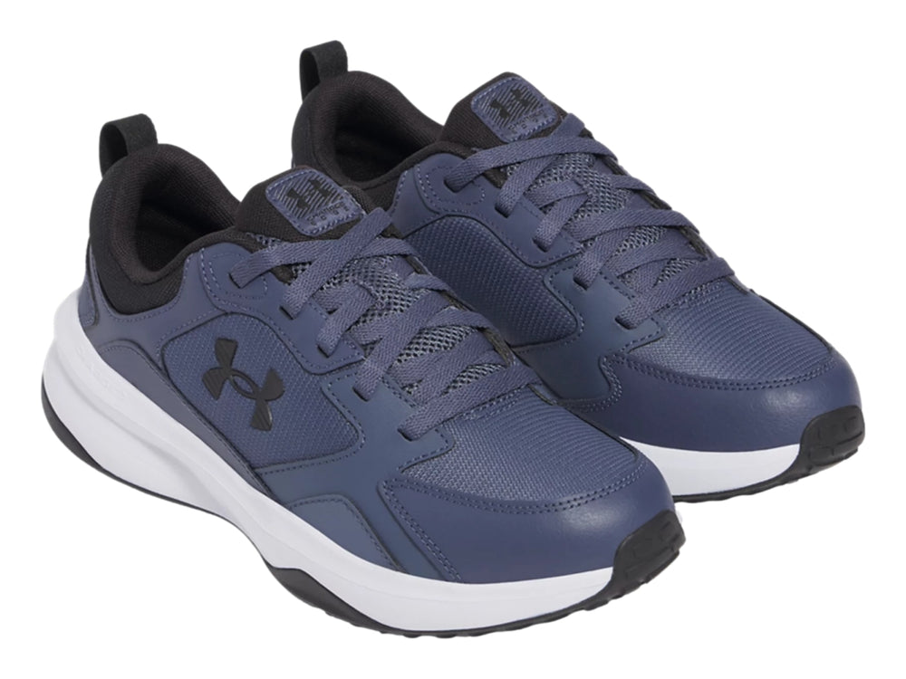 Tenis deportivos Under Armour color gris con suela blanca y detalles negros.