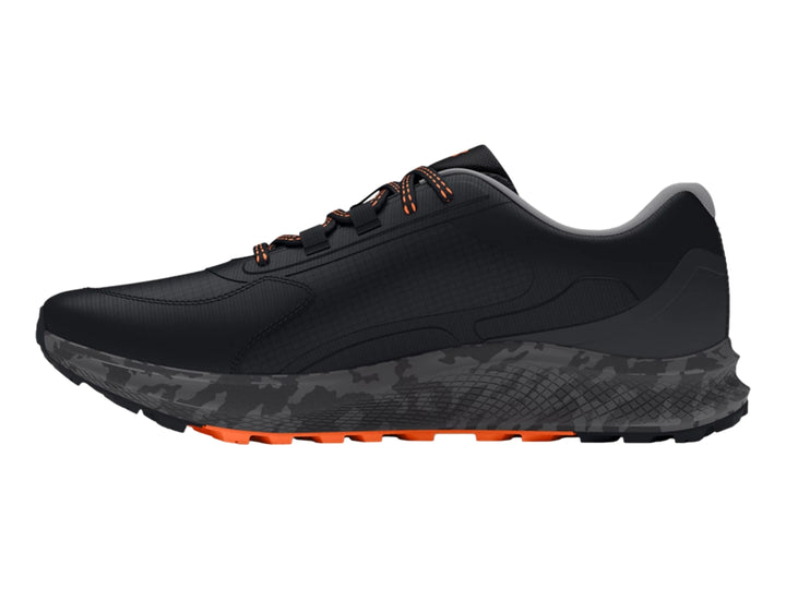 Tenis deportivos Under Armour color negro con detalles en naranja y suela gris.