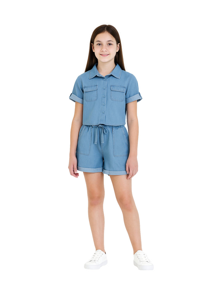 Niña vistiendo un conjunto de dos piezas en color azul claro compuesto por camisa y shorts.
