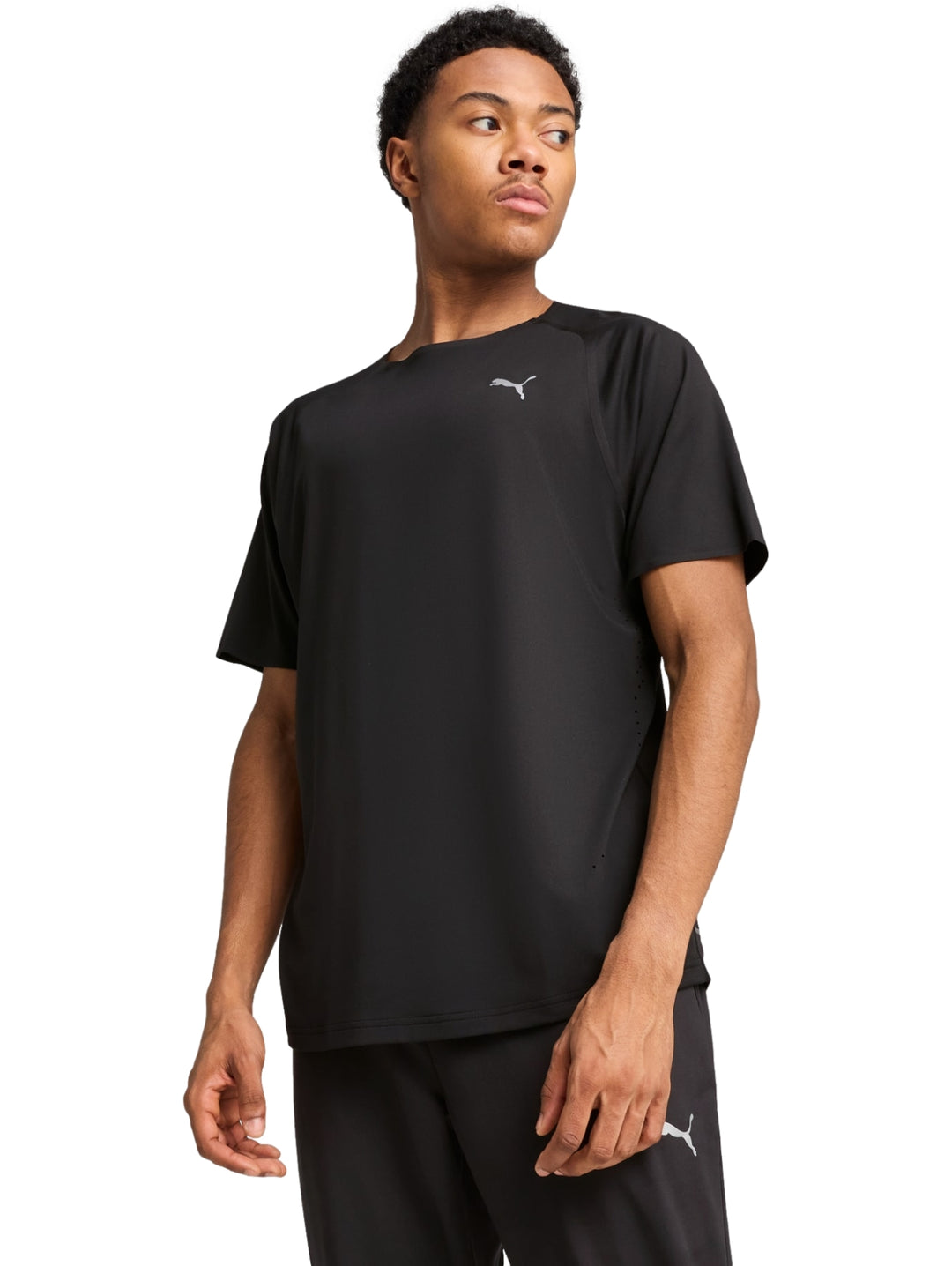 Hombre vistiendo una playera deportiva PUMA de color negro con logotipo blanco en el pecho.