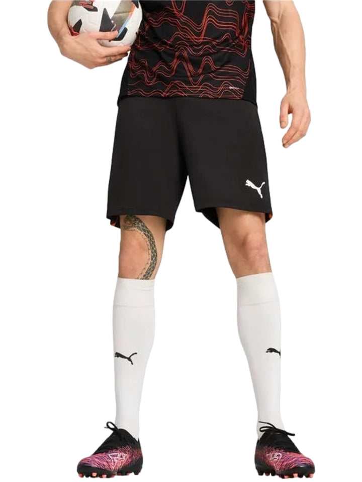 Hombre vistiendo shorts deportivos color negro de la marca PUMA con logo blanco en la pierna.