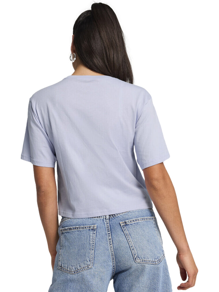 Mujer vistiendo camiseta cropped color lavanda con logotipo de PUMA en blanco.