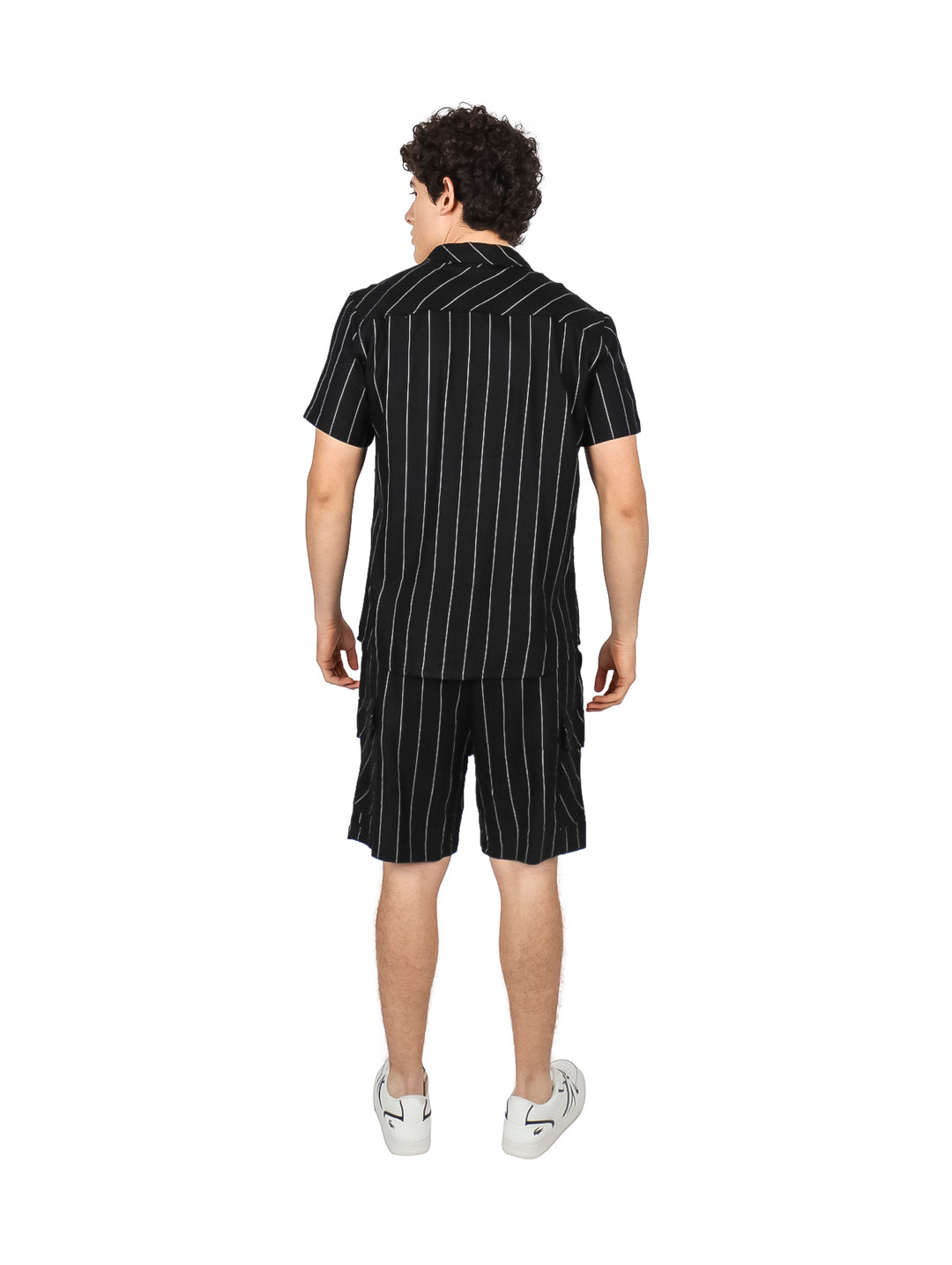 Hombre vistiendo conjunto de camisa y shorts negros con rayas verticales blancas.