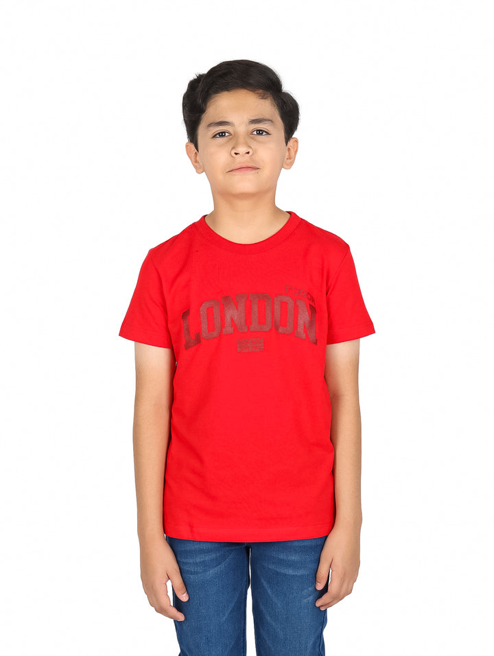 Niño vistiendo una playera roja de manga corta con la palabra LONDON estampada en el pecho.