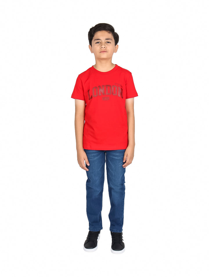 Niño vistiendo una playera roja de manga corta con la palabra LONDON estampada en el pecho.