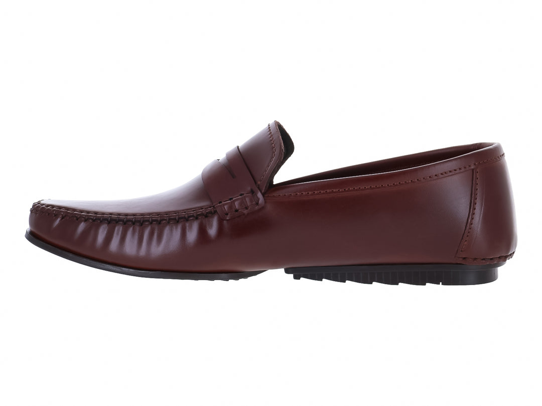 Zapato mocasín de cuero color marrón con suela negra y acabado brillante.