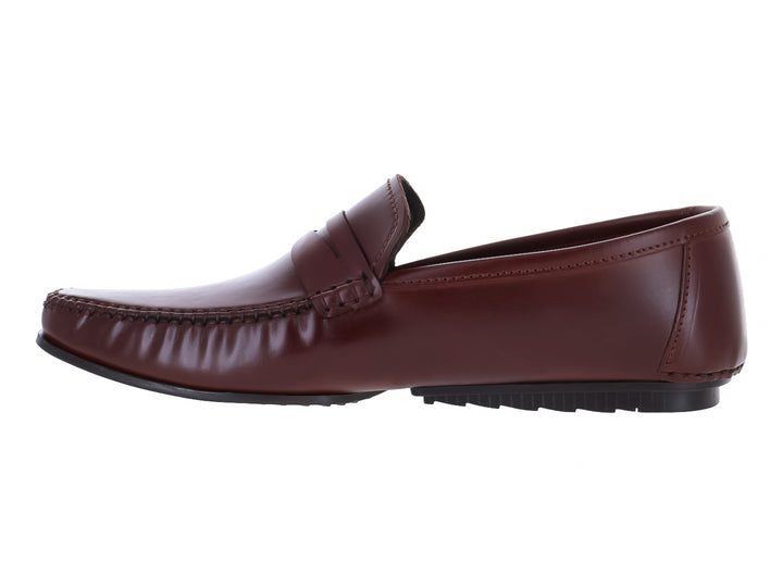 Zapato mocasín de cuero color marrón con suela negra y acabado brillante.
