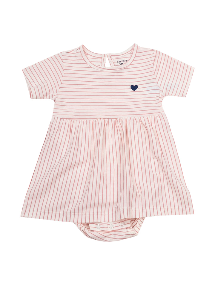 Niña pequeña con vestido rosa y blanco a rayas y un detalle de corazón azul en el pecho.