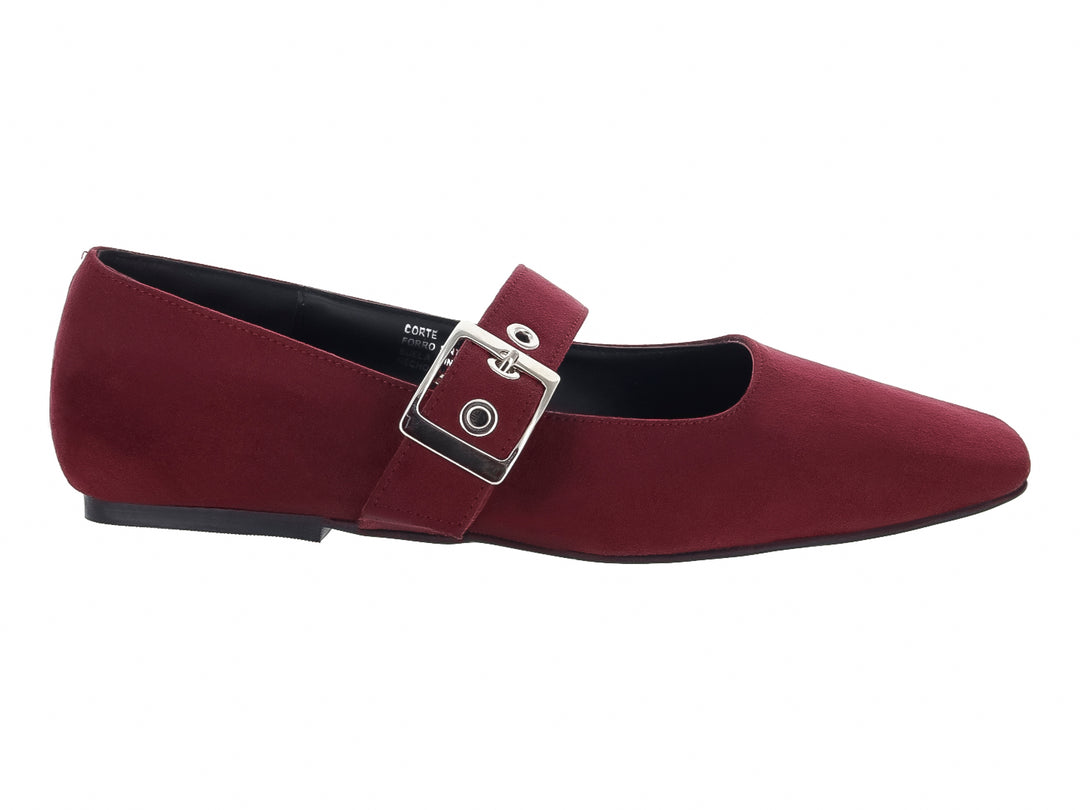 Zapato plano de gamuza color vino con correa y hebilla plateada.