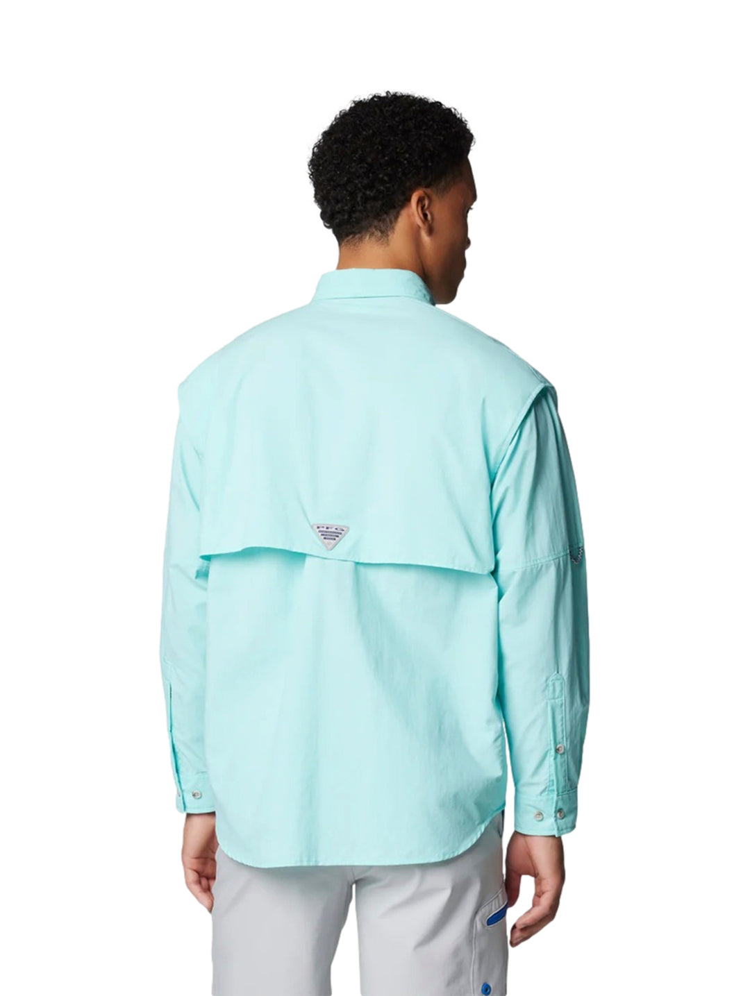 Hombre vistiendo una camisa Columbia PFG de manga larga en color azul claro Gulf Stream con bolsillos frontales.