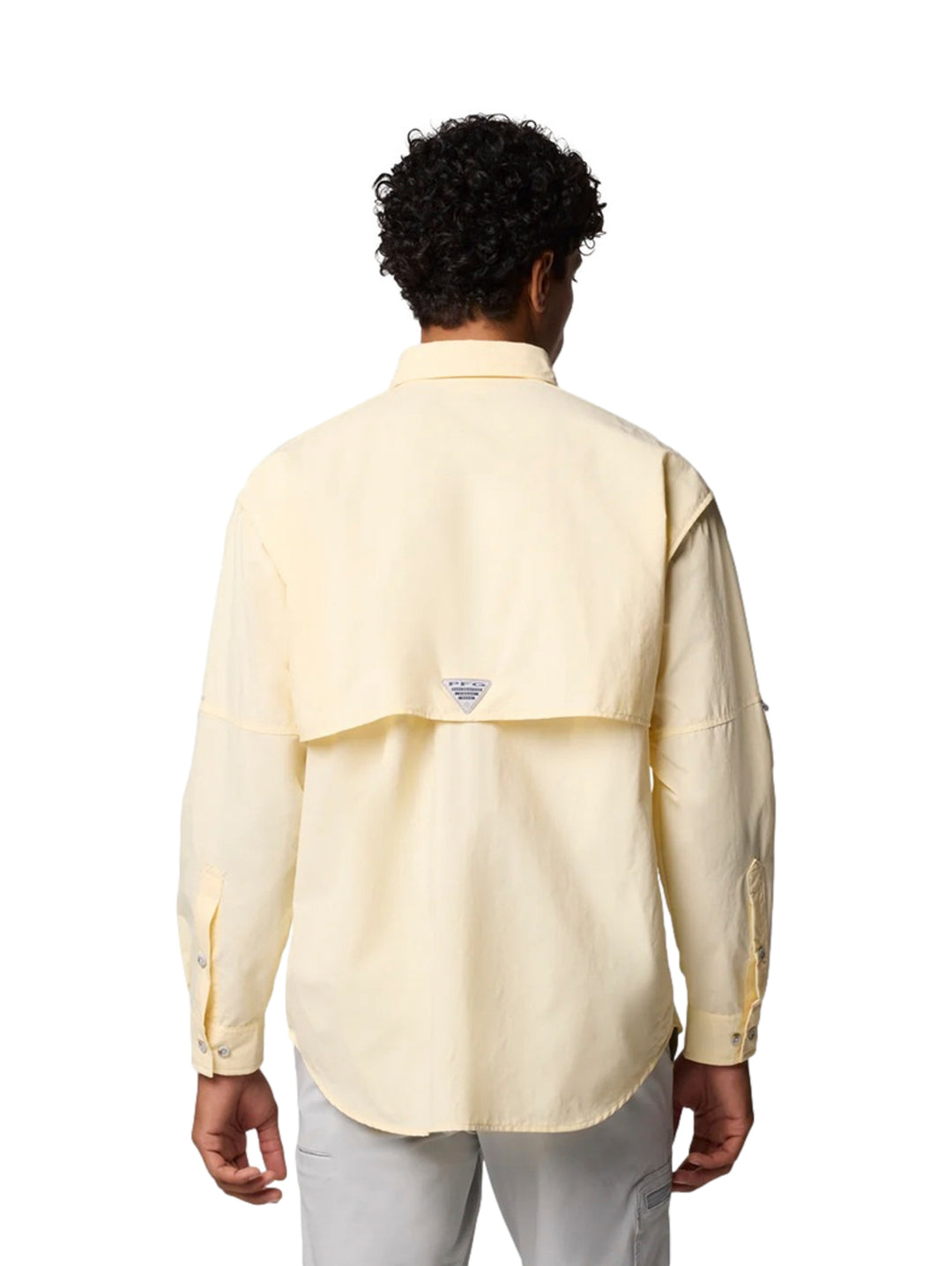 Hombre vistiendo una camisa Columbia de manga larga en color amarillo claro con bolsillos frontales.