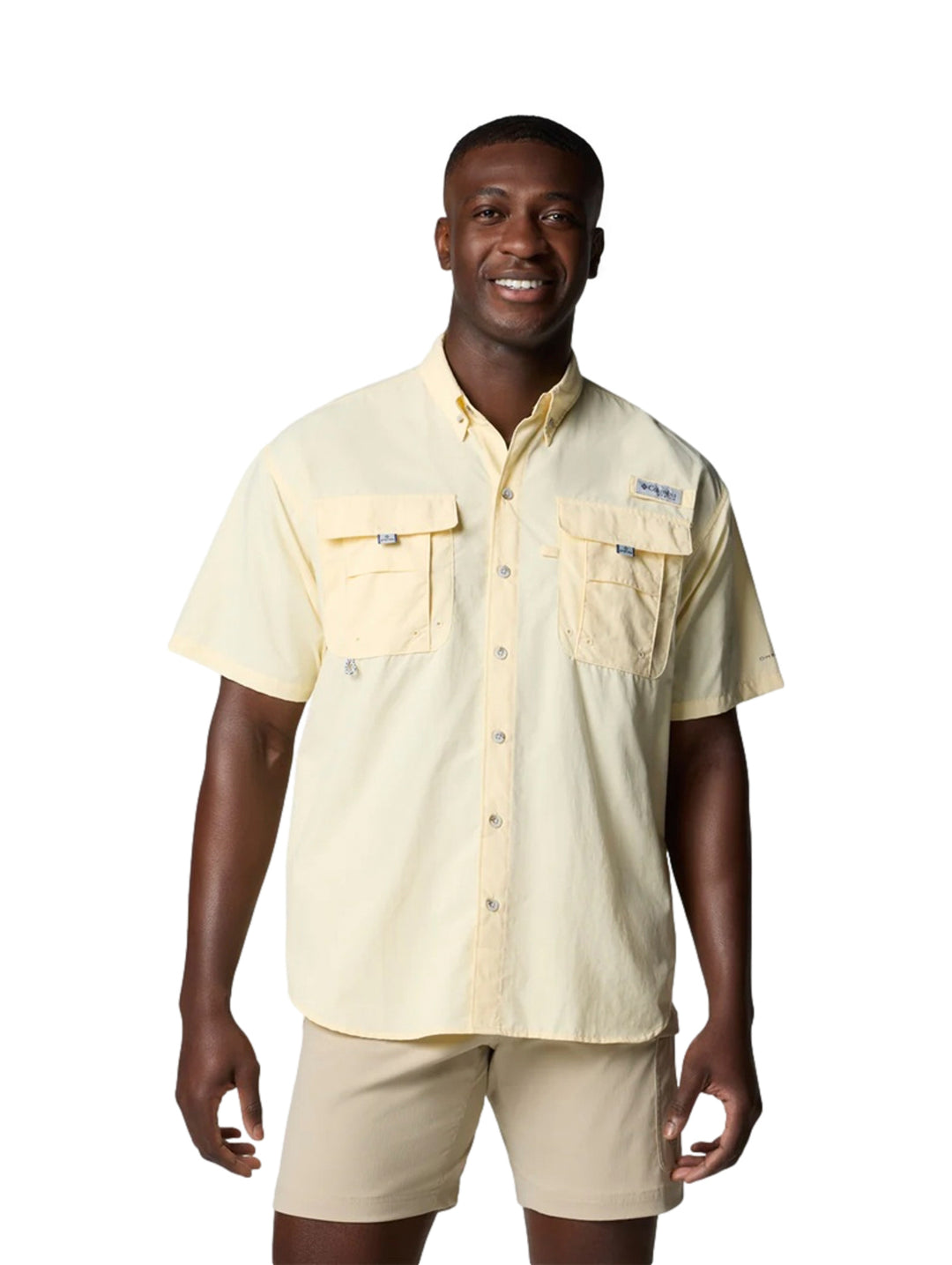 Hombre vistiendo una camisa Columbia de manga corta color amarillo pálido con dos bolsillos en el pecho.