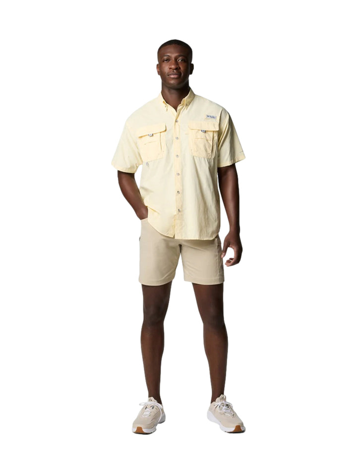 Hombre vistiendo una camisa Columbia de manga corta color amarillo pálido con dos bolsillos en el pecho.
