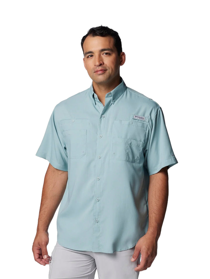 Hombre vistiendo una camisa Columbia de manga corta en color azul claro con bolsillos frontales.