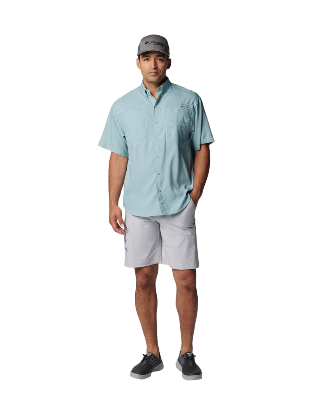 Hombre vistiendo una camisa Columbia de manga corta en color azul claro con bolsillos frontales.