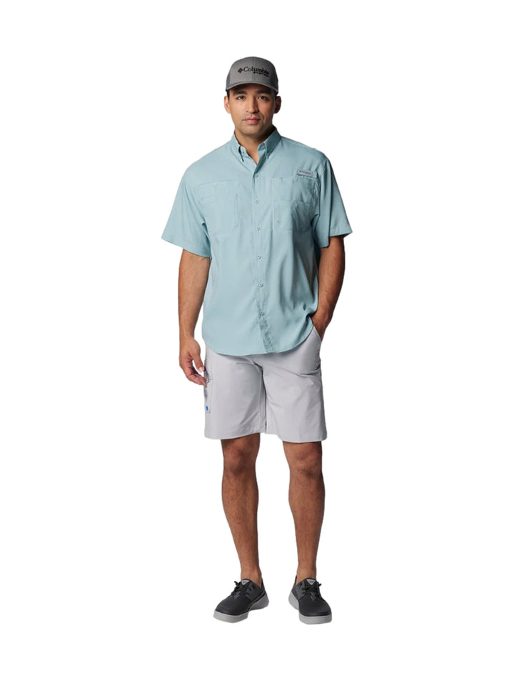 Hombre vistiendo una camisa Columbia de manga corta en color azul claro con bolsillos frontales.