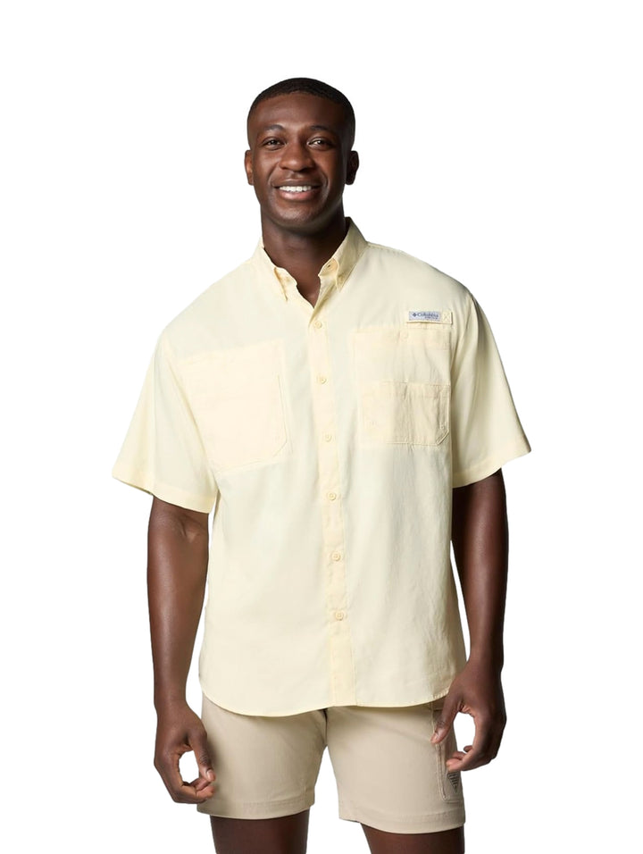 Hombre vistiendo una camisa Columbia de manga corta en color amarillo pálido con bolsillos frontales.