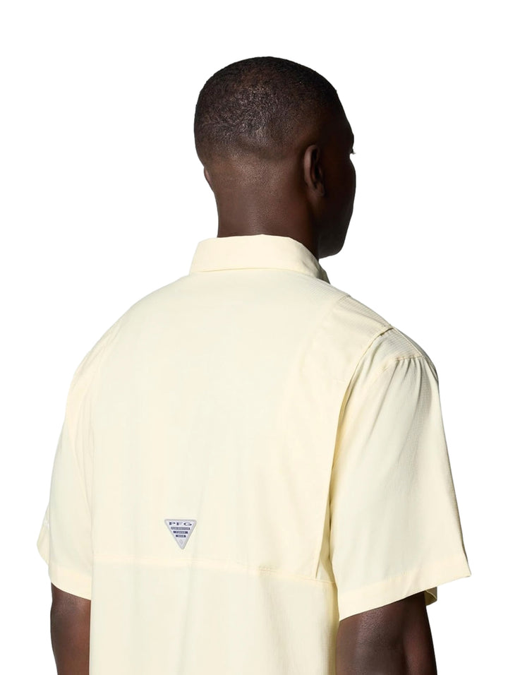 Hombre vistiendo una camisa Columbia de manga corta en color amarillo pálido con bolsillos frontales.