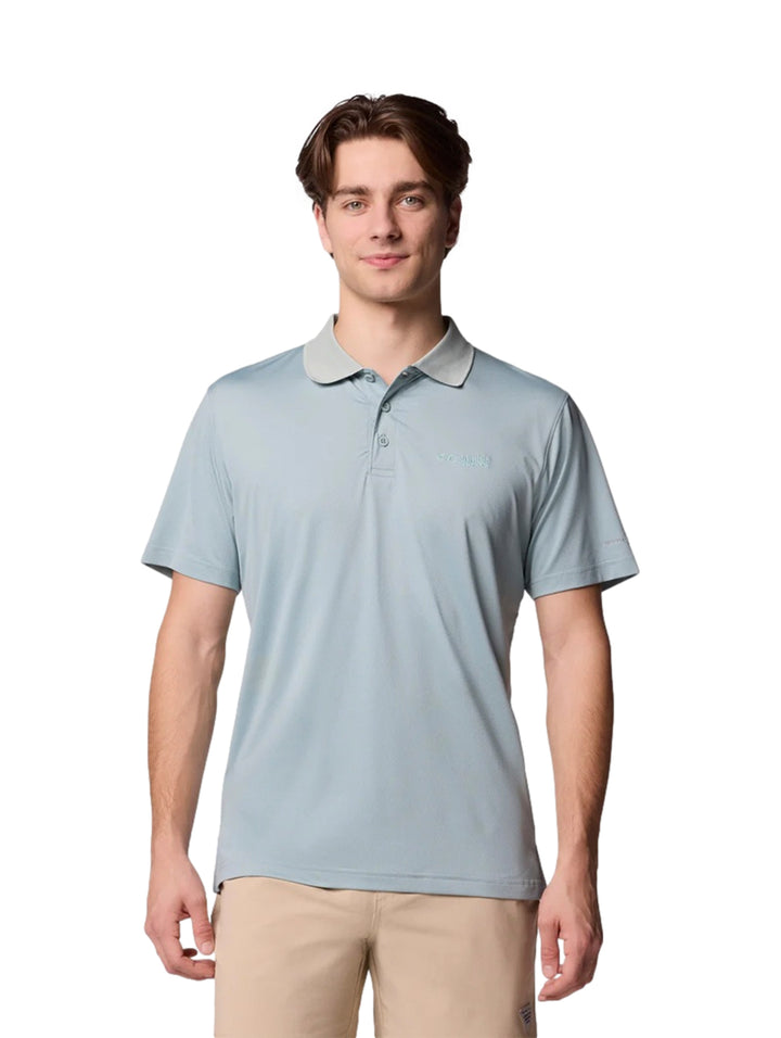Hombre vistiendo una camiseta polo Columbia de color azul claro con cuello gris y pantalones beige.