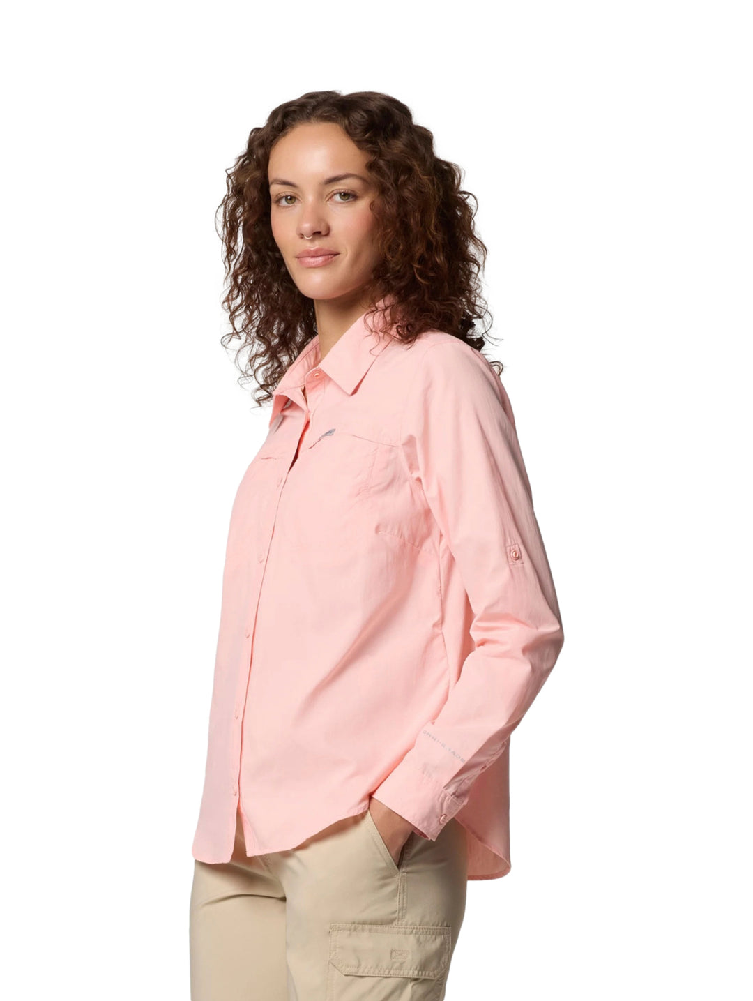 Mujer vistiendo una camisa Columbia de manga larga en color rosa sand con bolsillos frontales.