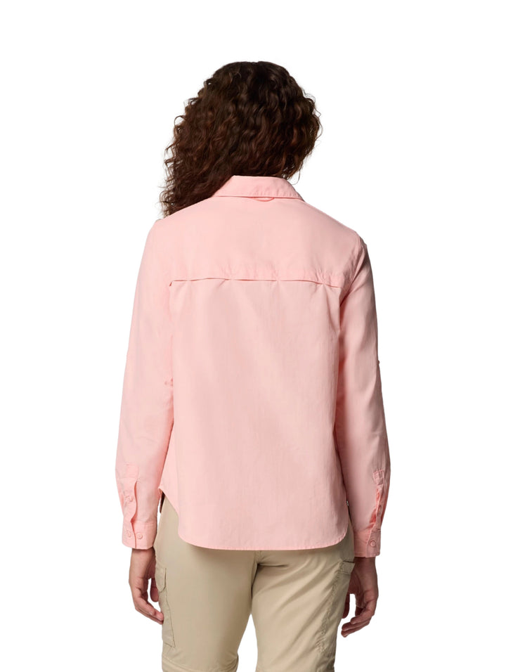 Mujer vistiendo una camisa Columbia de manga larga en color rosa sand con bolsillos frontales.